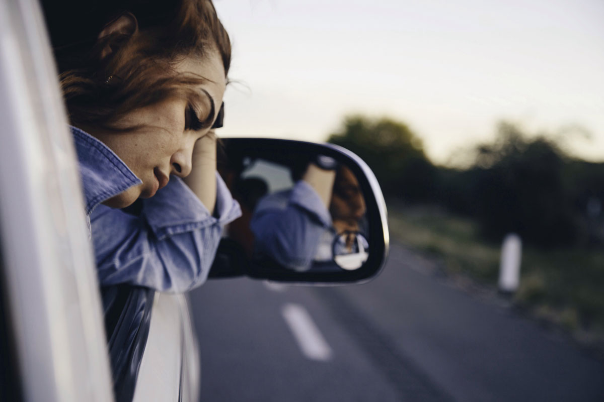 latina young woman looking out of car window